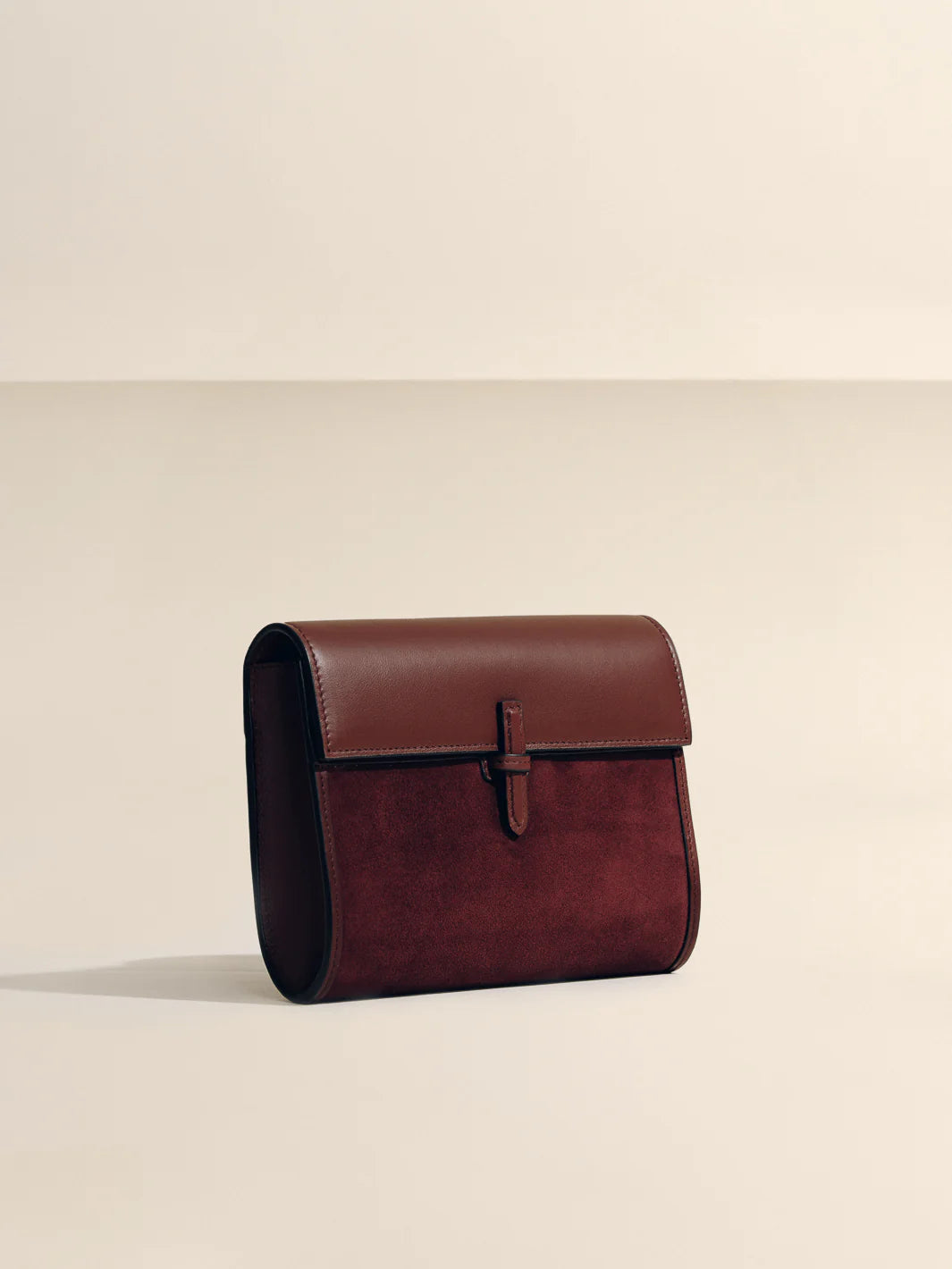 Brown leather clutch bag on a beige background