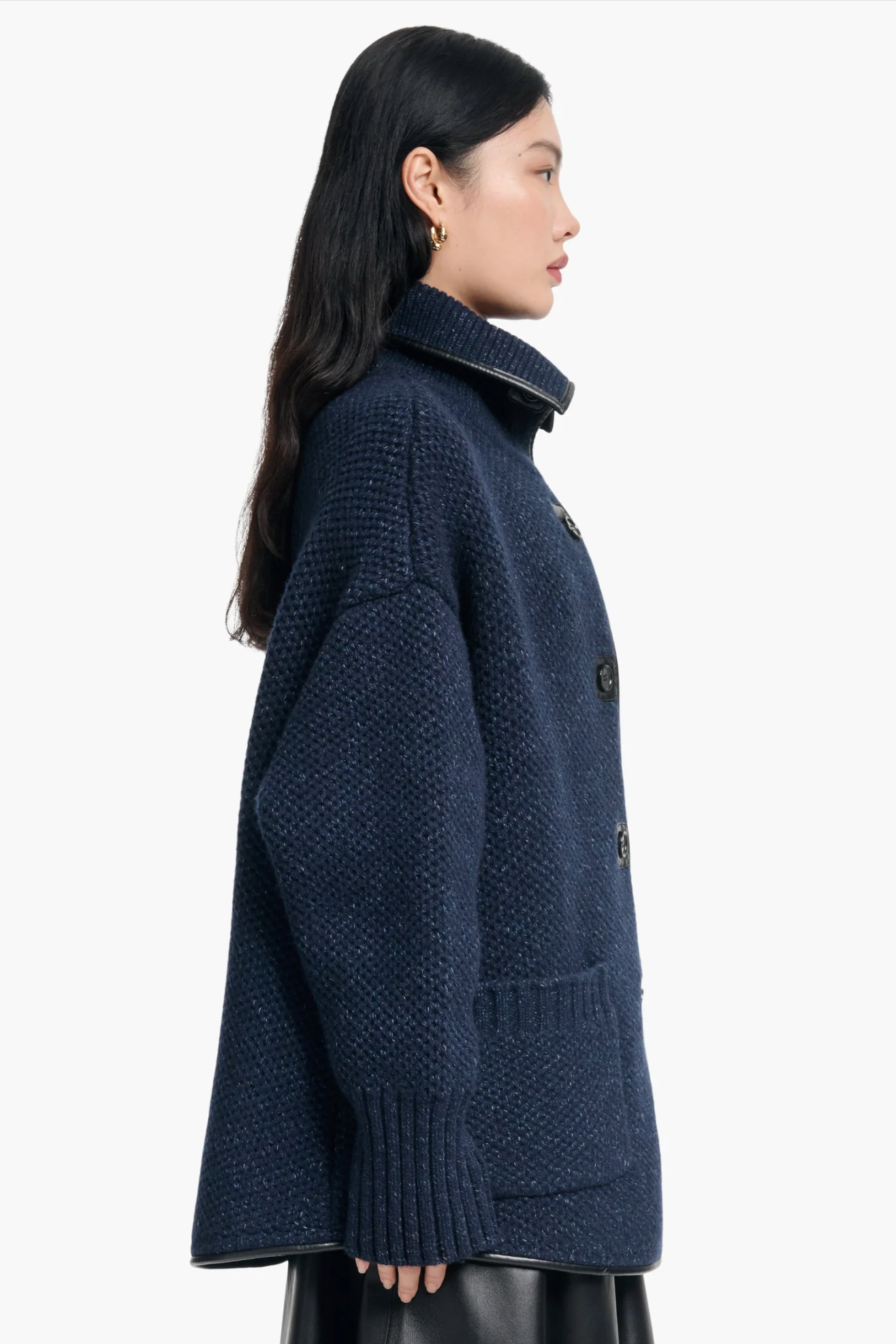 Woman wearing a dark blue knitted sweater on a white background