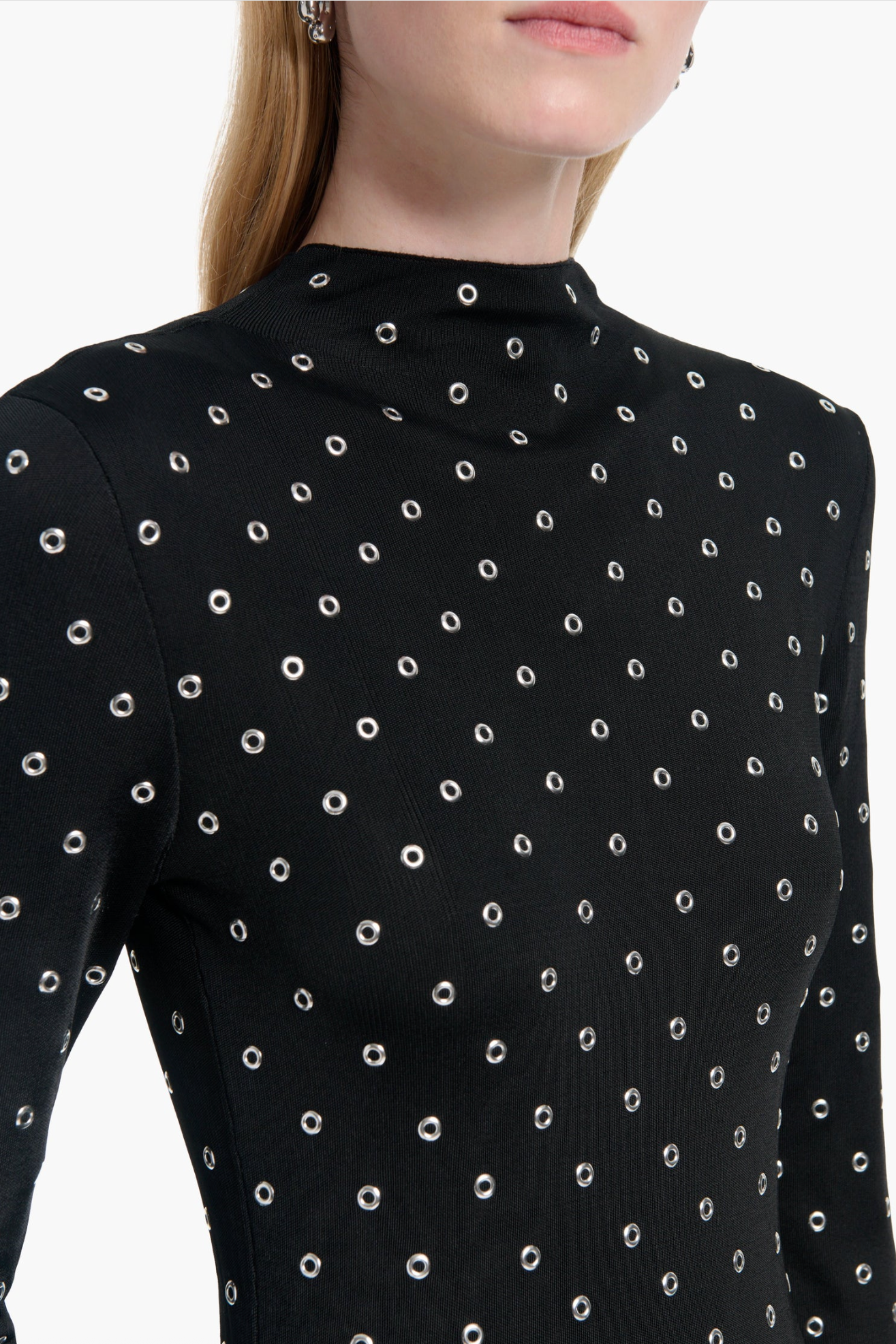 Black long-sleeve top with white polka dot pattern on a white background