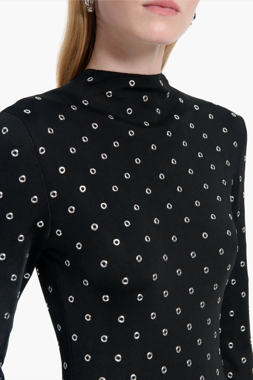 Black long-sleeve top with white polka dot pattern on a white background